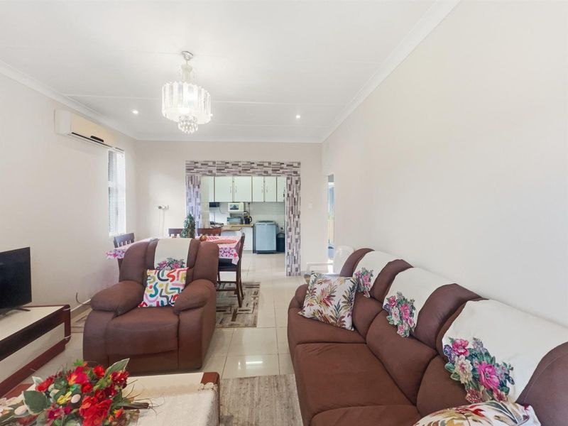 Open plan living and dining area featuring tiled flooring, a split-system air conditioner, and a direct view into the adjacent kitchen space.