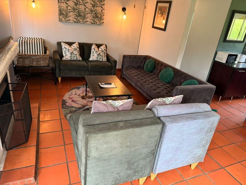 A living room area featuring terracotta floor tiles and a built-in fireplace, providing a warm and functional space.