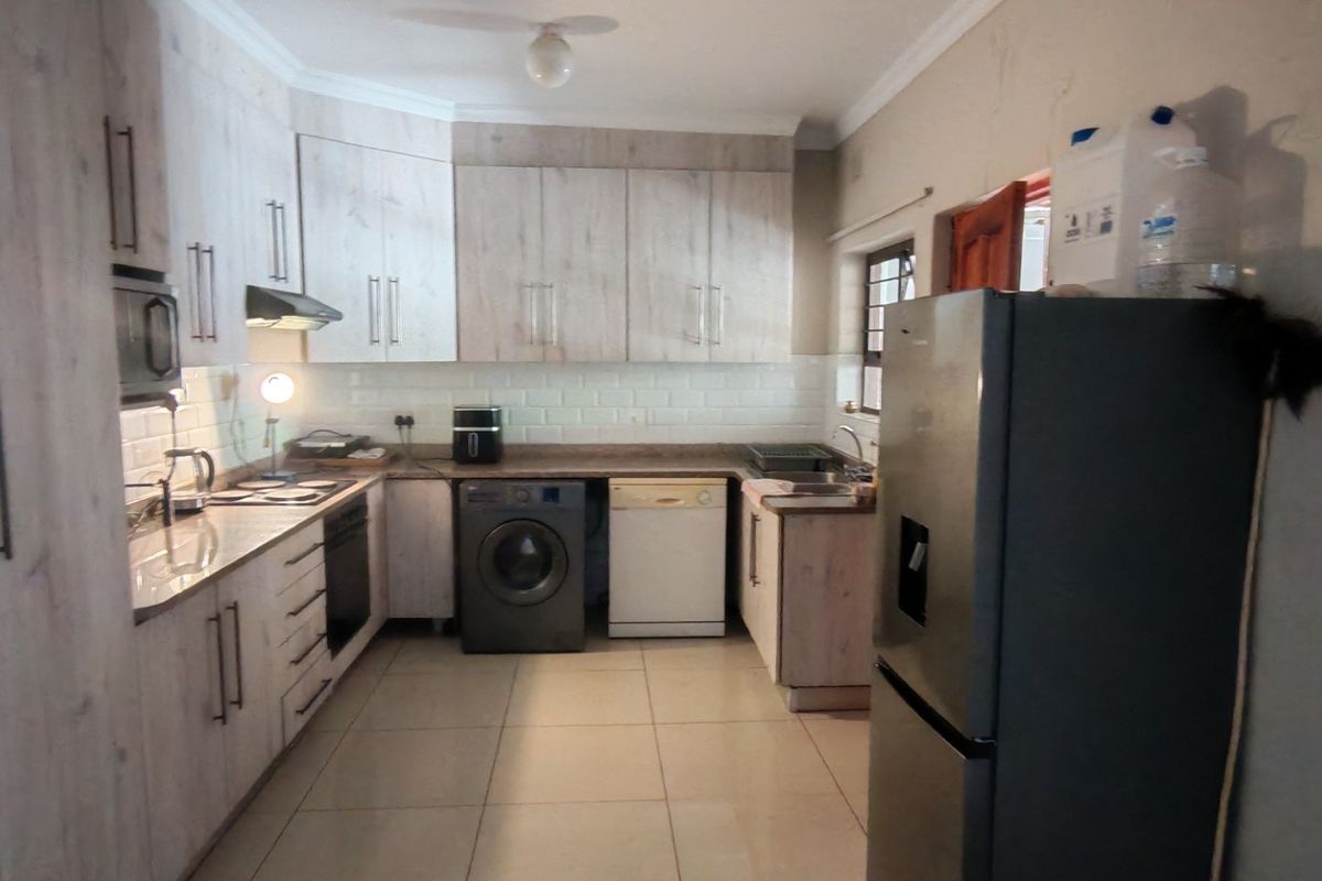 A functional kitchen featuring light wood-look cabinetry, subway tile backsplash, integrated oven, and tiled flooring, offering a practical layout for daily meal preparation.