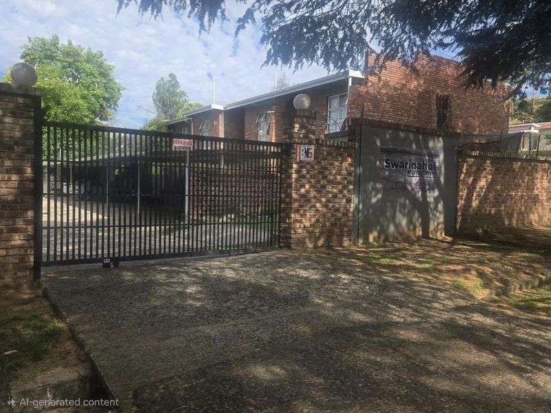 Front entrance view of Swarinahof townhouse complex featuring a secure metal gate, brick boundary wall, and paved driveway access.