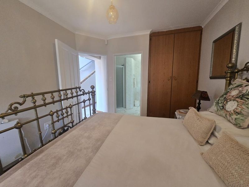 A bedroom featuring a built-in wooden wardrobe and direct access to an en-suite bathroom.