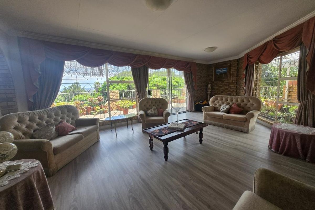 Spacious living room featuring laminate flooring, exposed brick accents, and large sliding glass doors that provide ample natural light and access to the outdoors.