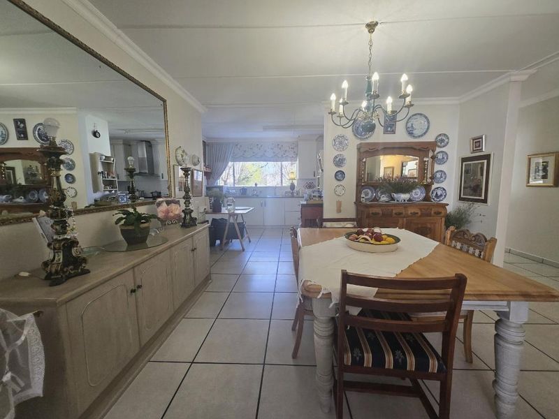 Open plan dining and kitchen area featuring tiled flooring, traditional cabinetry, and a functional layout connecting the cooking and dining spaces.