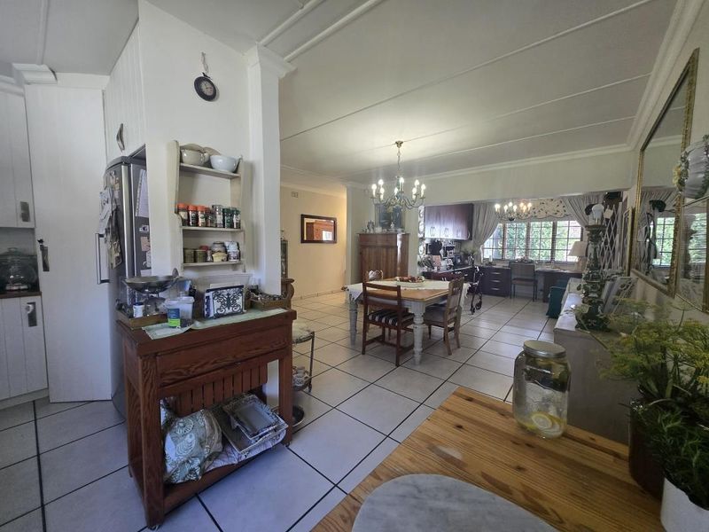 Spacious open-plan living and dining area featuring tiled flooring, neutral walls, and integrated cabinetry, offering a versatile layout for family living.