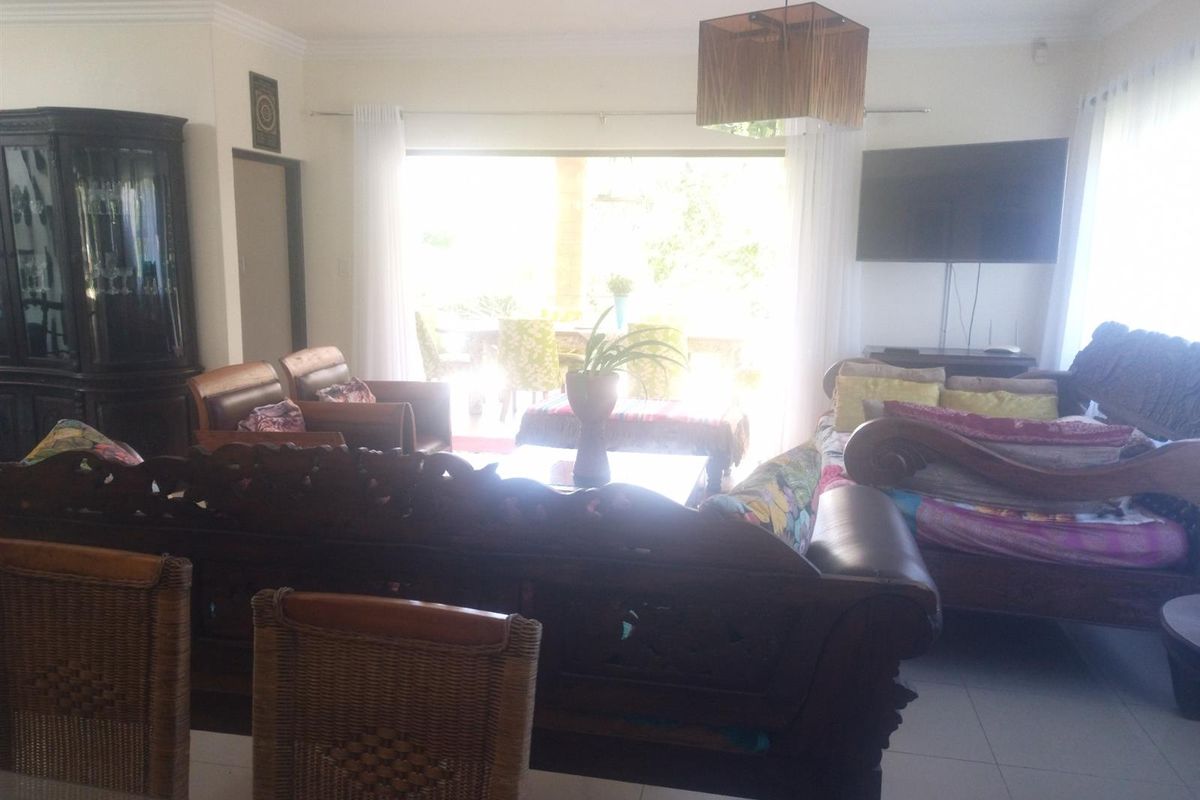 Spacious living area featuring tiled flooring and large sliding glass doors that provide access to the outdoor patio area.