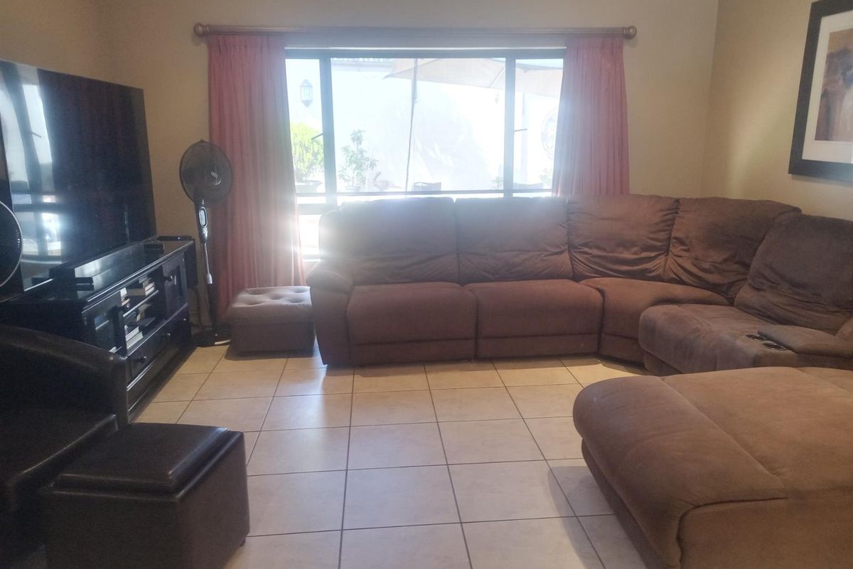 A living room featuring tiled flooring and a large window that allows for natural light.