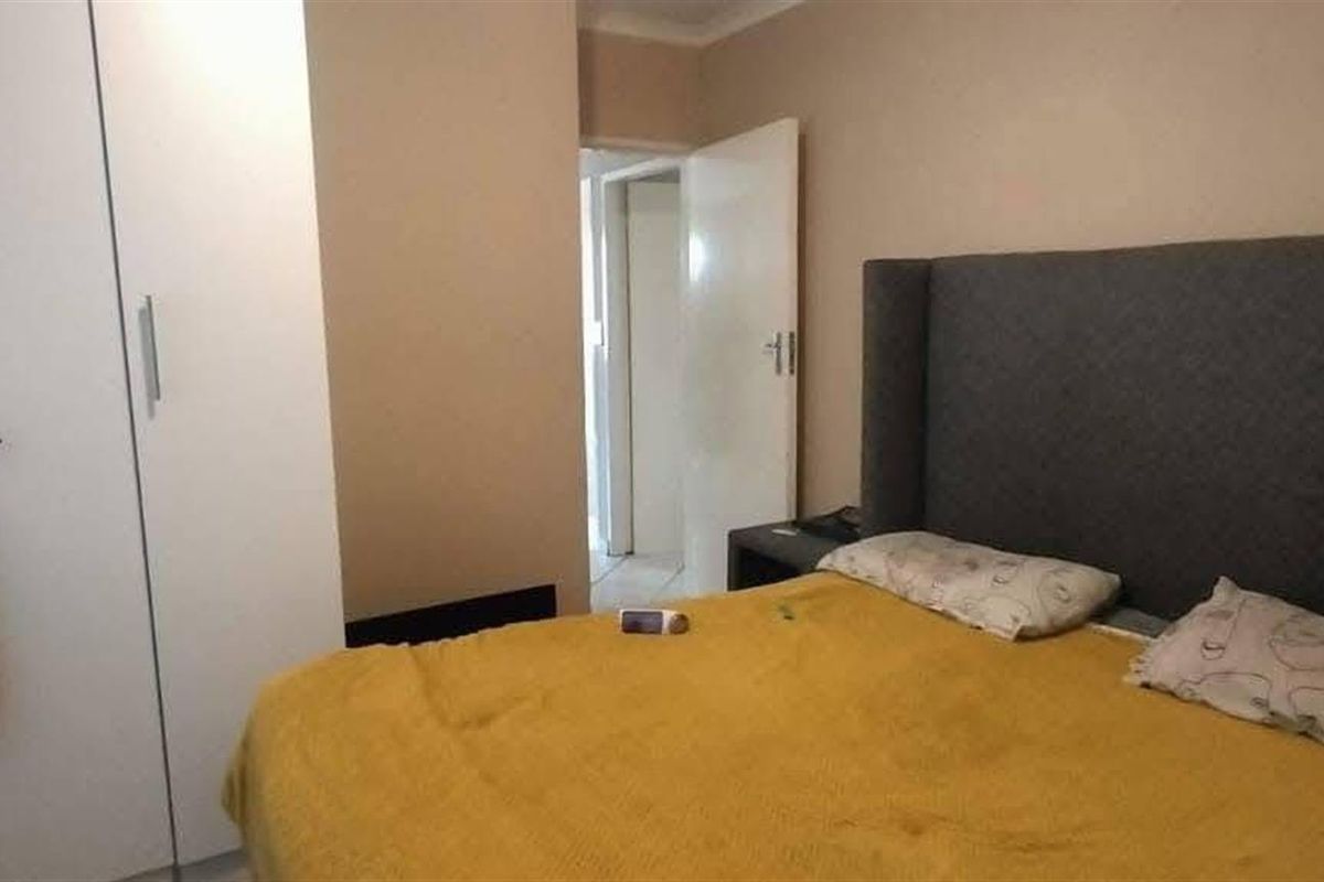 A bedroom featuring built-in wardrobes and a neutral color palette, providing a functional and comfortable living space.
