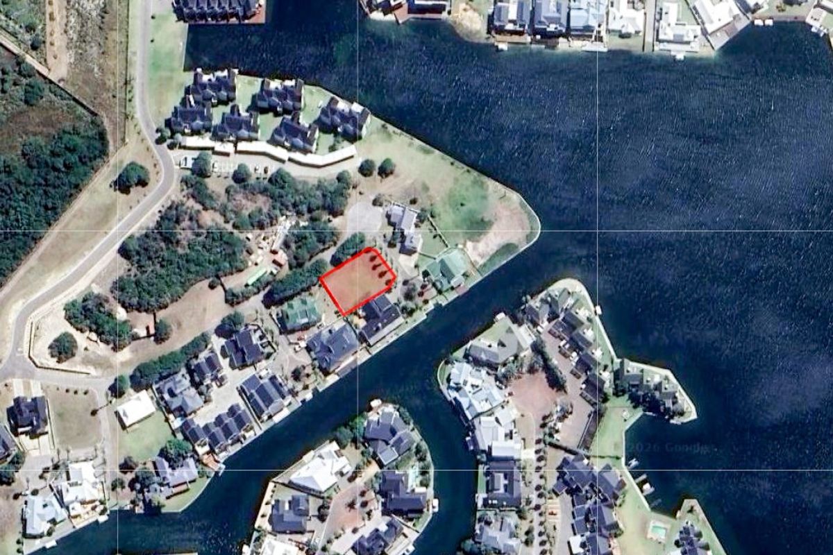 An aerial view of a vacant residential plot located within a waterfront estate, highlighting its position and surrounding neighborhood layout.