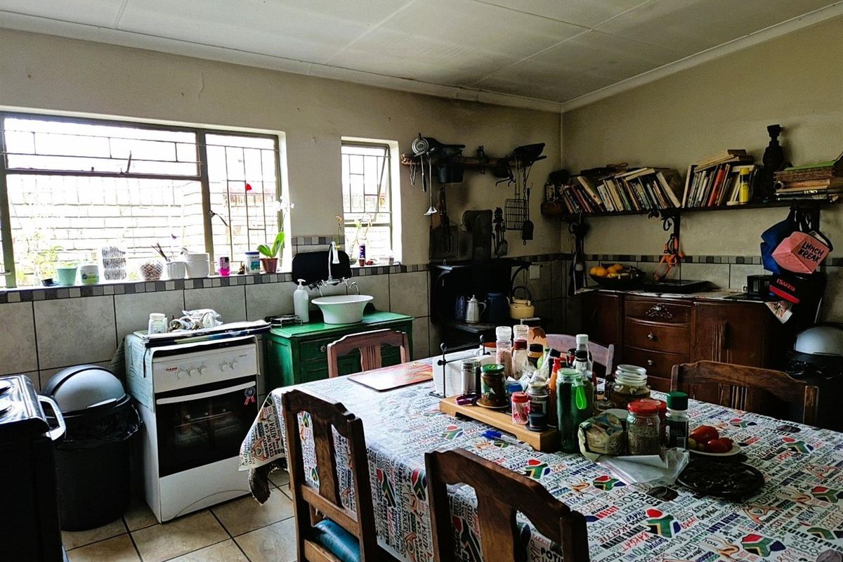 A functional kitchen space featuring a freestanding stove, tiled splashbacks, and built-in shelving, offering a practical layout for daily meal preparation.