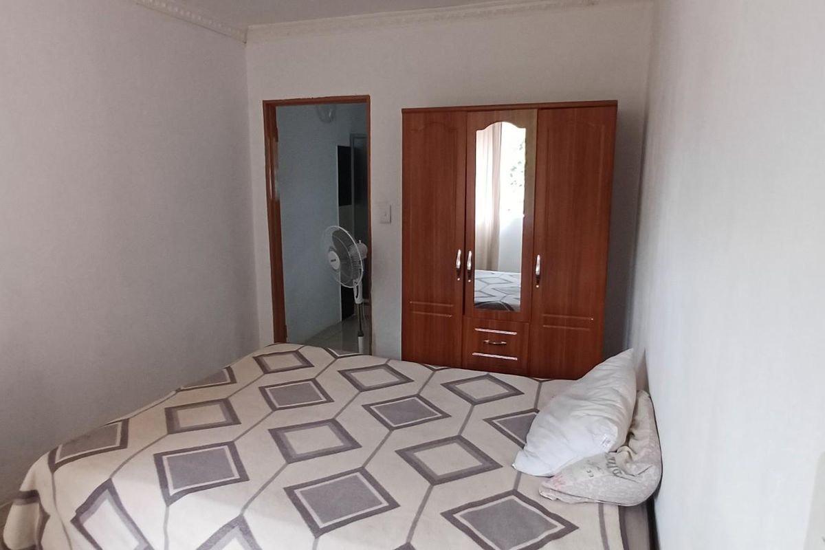 A standard bedroom featuring tiled flooring and a doorway leading to an adjacent space.