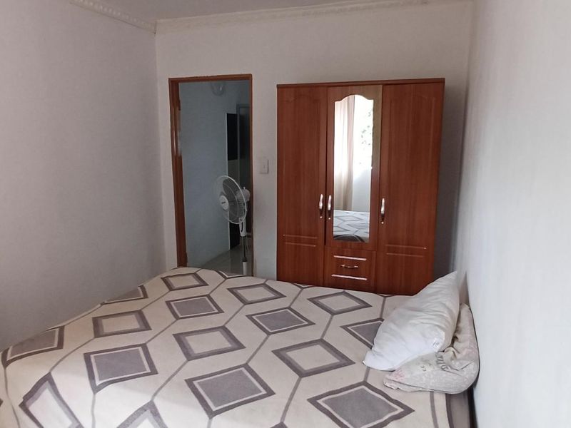 A standard bedroom featuring tiled flooring and a doorway leading to an adjacent space.