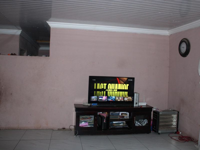 A living room area featuring tiled flooring and a tongue-and-groove ceiling with crown molding.