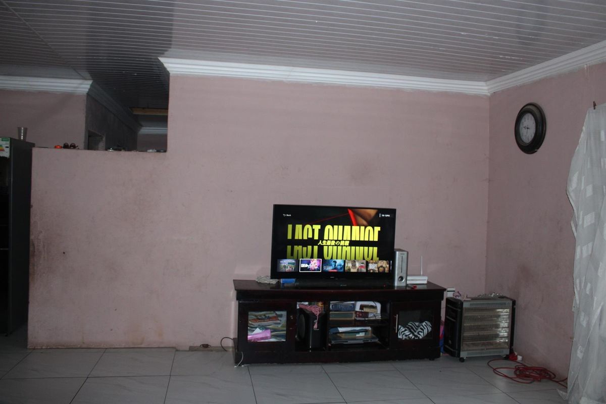A living room area featuring tiled flooring and a tongue-and-groove ceiling with crown molding.