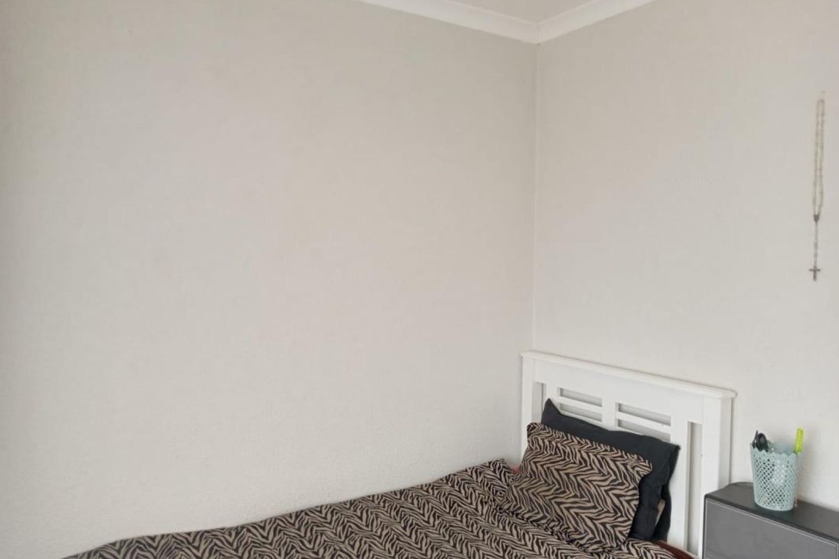 A simple bedroom featuring neutral wall finishes and a standard layout, suitable for personal customization.