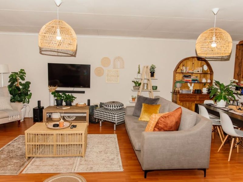 An open-plan living and dining area featuring warm laminate flooring and modern pendant lighting, creating a comfortable and functional space for daily living.