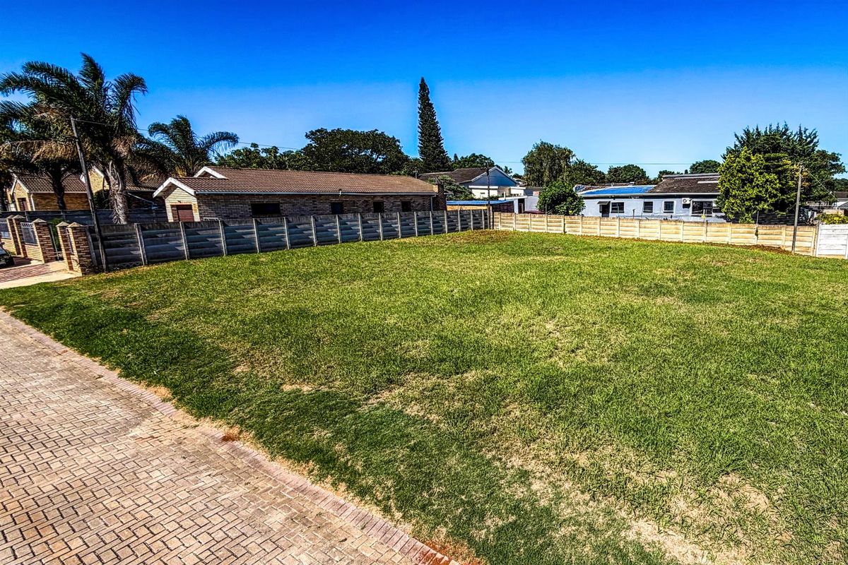A level, grassed residential vacant stand featuring perimeter precast concrete walling and paved street frontage in an established neighborhood.