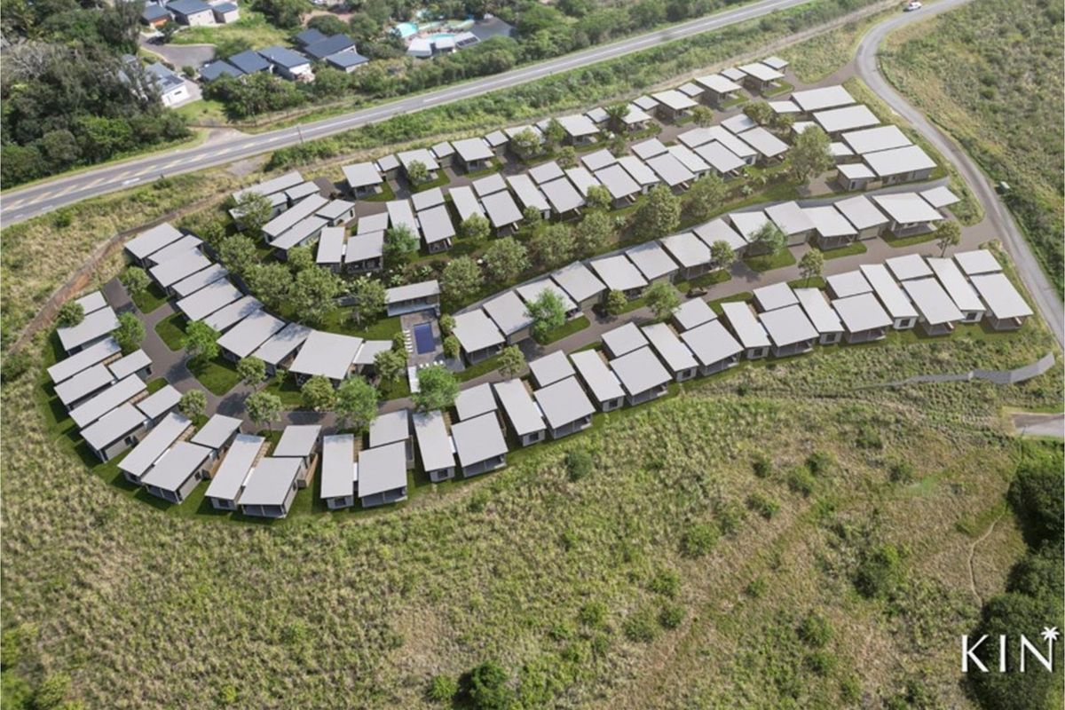 Aerial view of a modern residential estate development featuring multiple housing units, communal pool area, and landscaped surroundings.