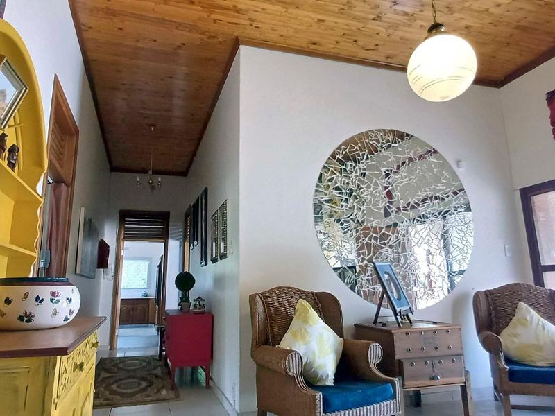 A living area featuring a warm timber-paneled ceiling, neutral walls, and a sliding glass door providing natural light.