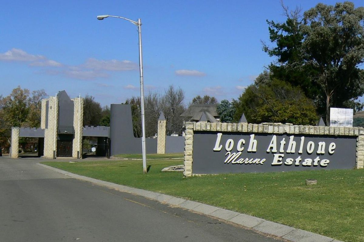 Entrance view of Loch Athlone Marine Estate featuring stone-clad signage, security gatehouse, and paved access road.