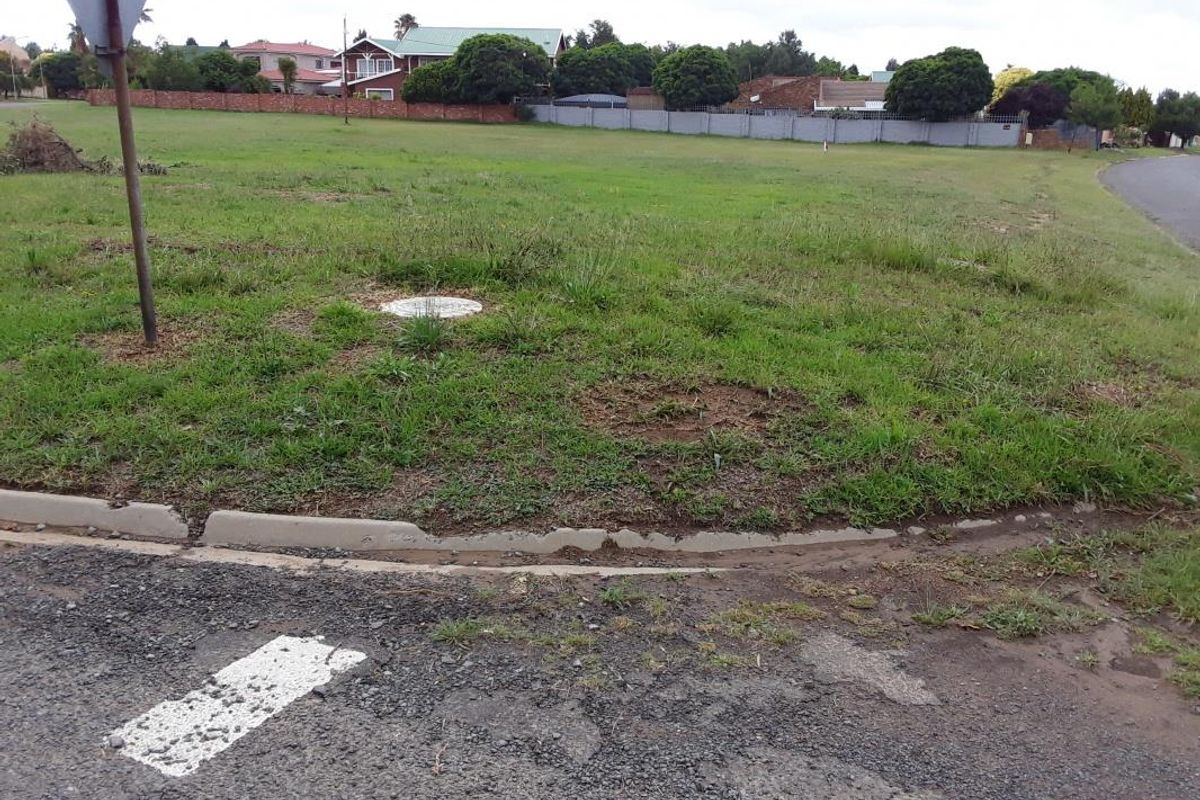A street-level view of the vacant residential land showing the kerb and surrounding grass area.