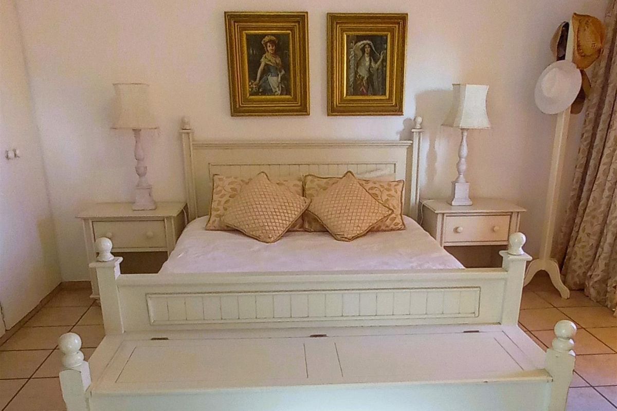 A bedroom featuring tiled flooring and a neutral color palette, providing a comfortable and functional sleeping space.