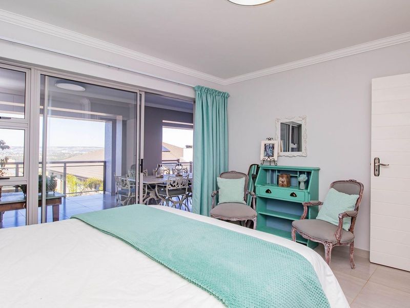 Spacious bedroom featuring large sliding glass doors that open onto a private balcony with scenic views.