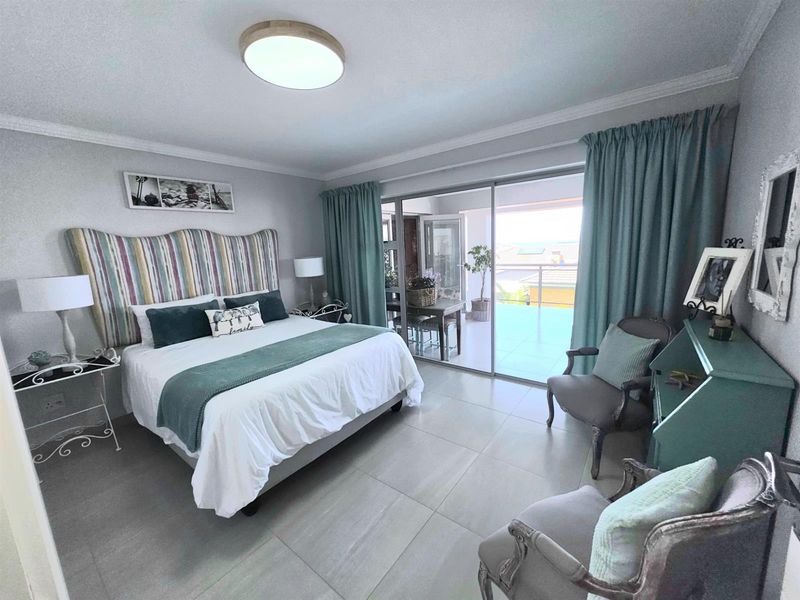 Spacious bedroom featuring large sliding glass doors that open onto a private balcony, providing ample natural light and seamless indoor-outdoor flow.
