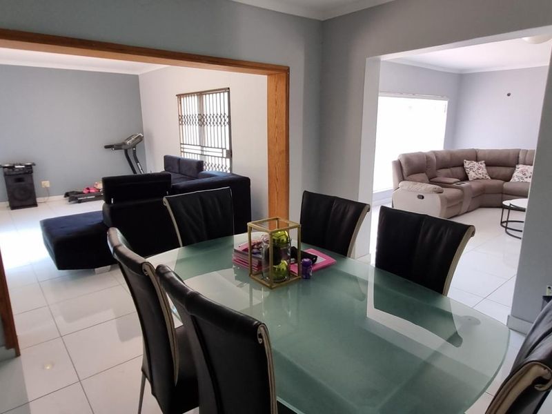 Open plan living and dining area featuring tiled flooring and neutral wall finishes, connecting multiple living spaces.