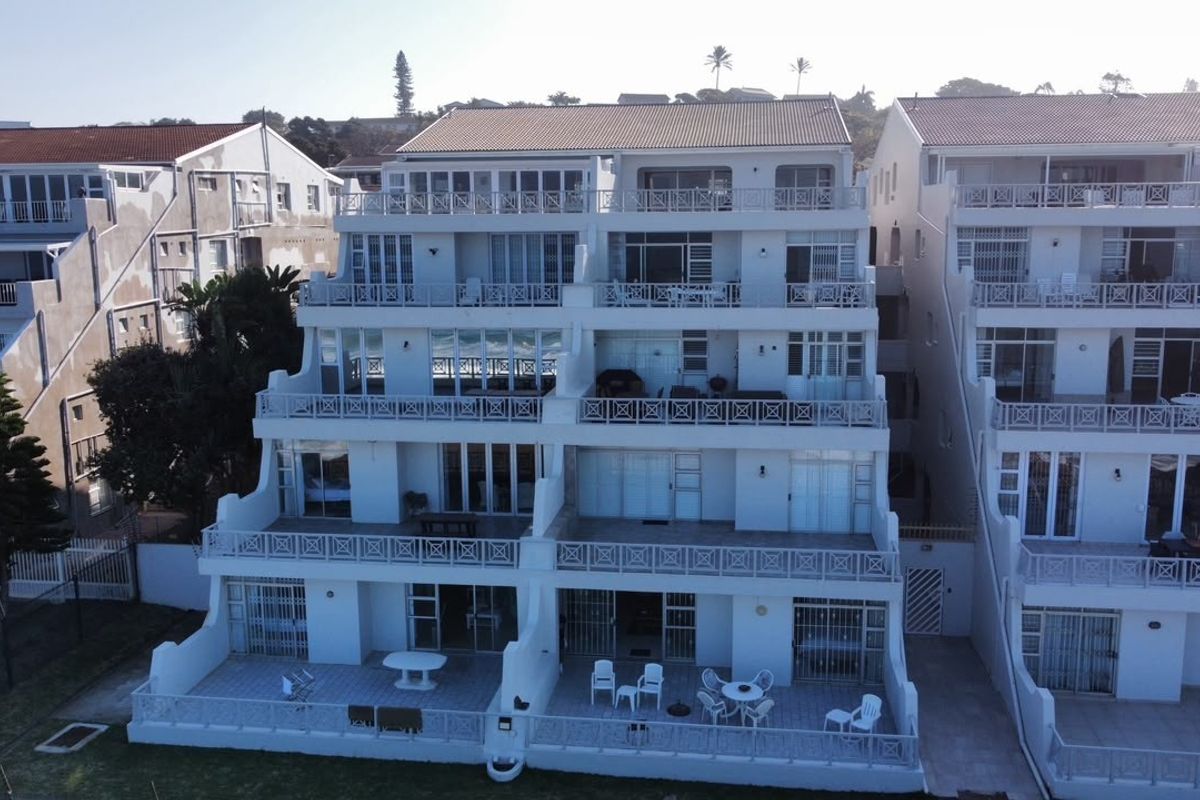 Aerial view of a multi-story apartment complex featuring tiered balconies, sliding glass doors, and security gates on each level.