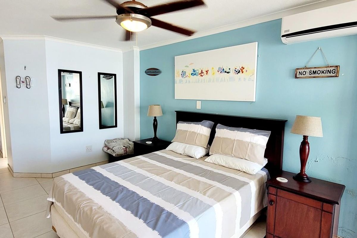 A bedroom featuring tiled flooring, a ceiling fan, and a wall-mounted air conditioning unit.