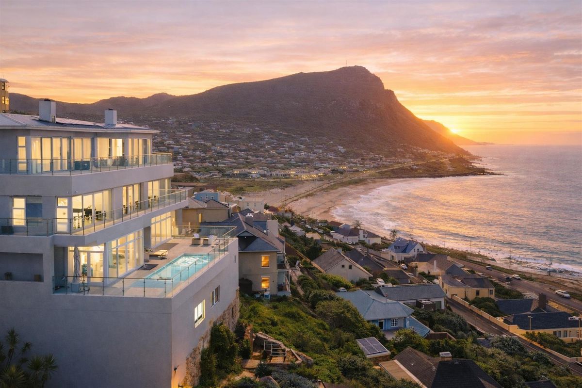 Stunning aerial view of a multi-level coastal residence featuring a private swimming pool, expansive glass balconies, and panoramic sunset ocean views.
