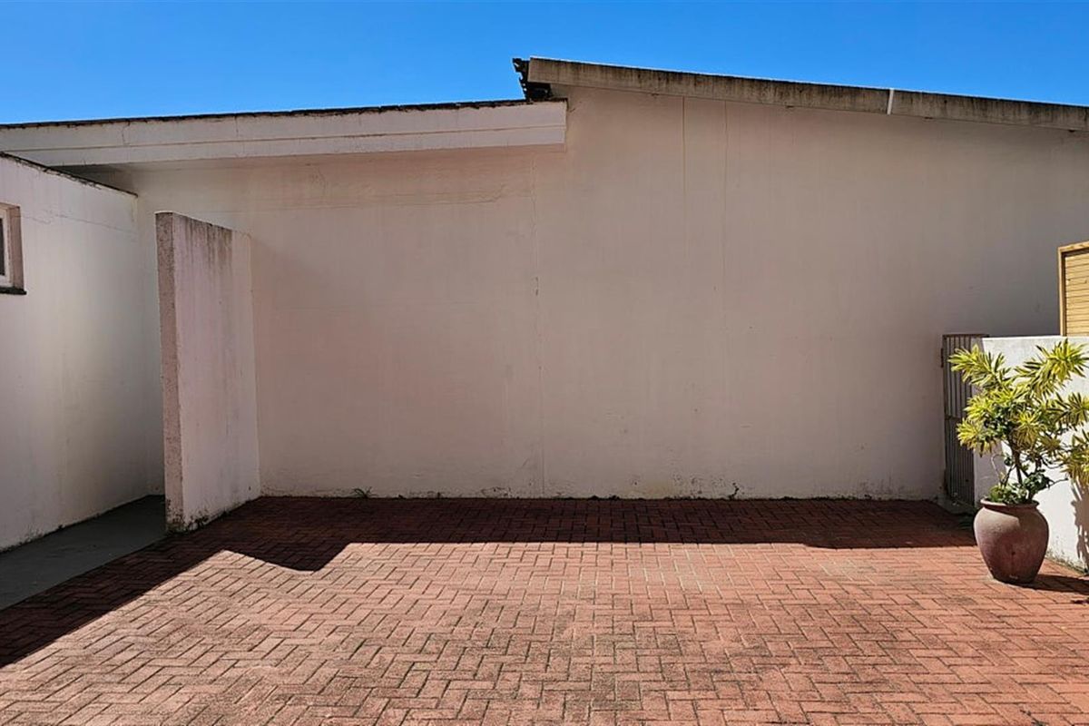 A private rear courtyard featuring brick paving and perimeter walls, offering a blank canvas for outdoor landscaping or entertainment area development.
