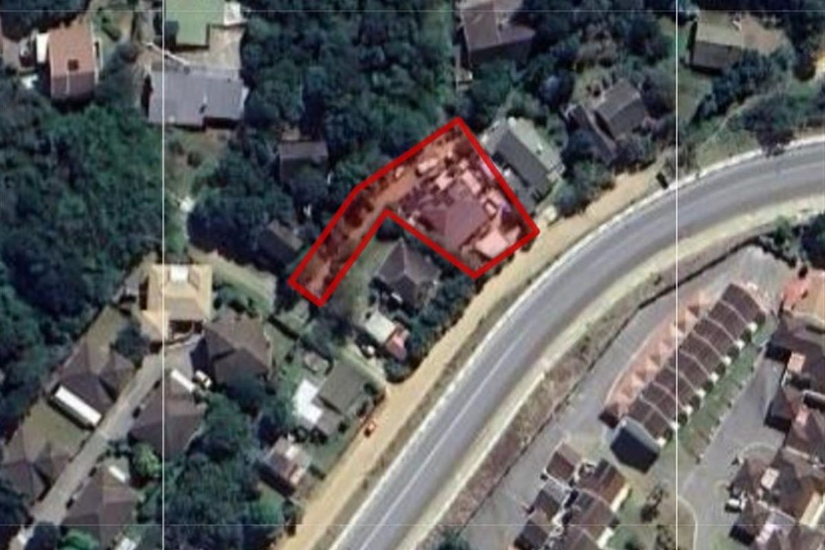 An aerial view of the property highlighting the plot boundaries and surrounding residential neighborhood.