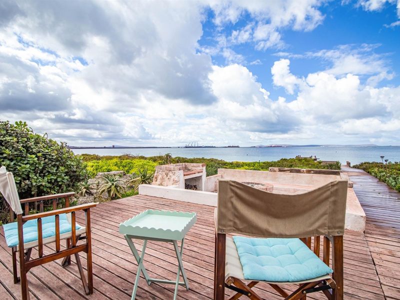 Outdoor timber deck featuring a built-in masonry braai area with expansive coastal and ocean views.