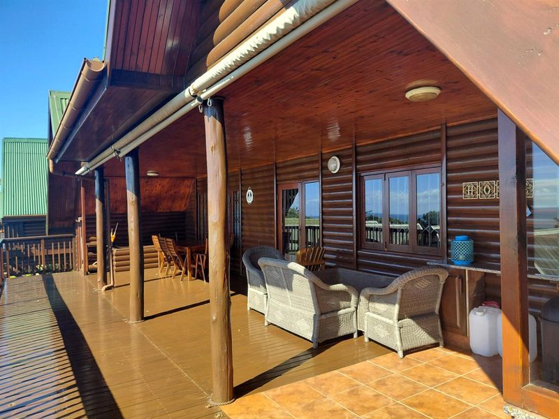 A spacious covered timber deck featuring log-style wall cladding, tiled flooring, and integrated lighting, providing an ideal outdoor entertainment area.