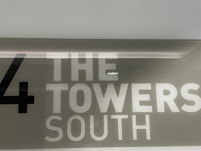 A clear signage display for The Towers South, indicating the building location and level.