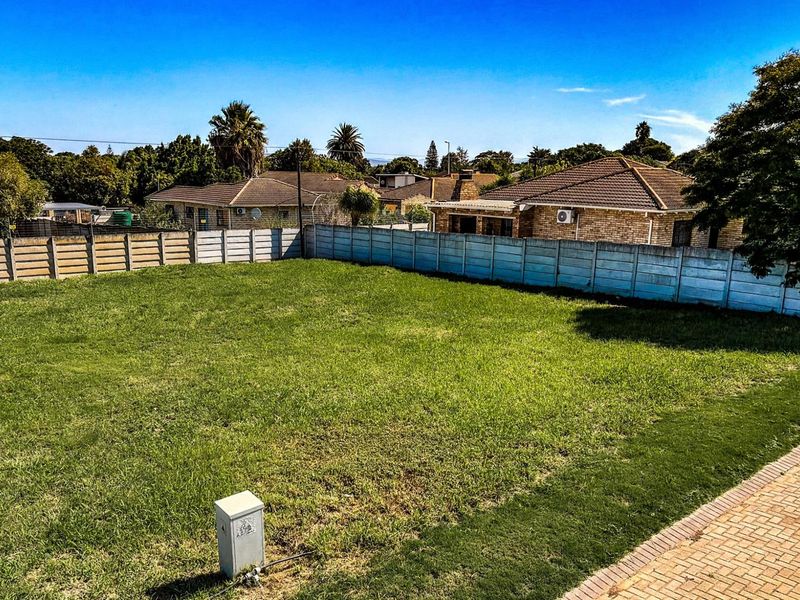 A level, grassed residential vacant stand enclosed by precast concrete perimeter walling, situated in an established suburban neighborhood.