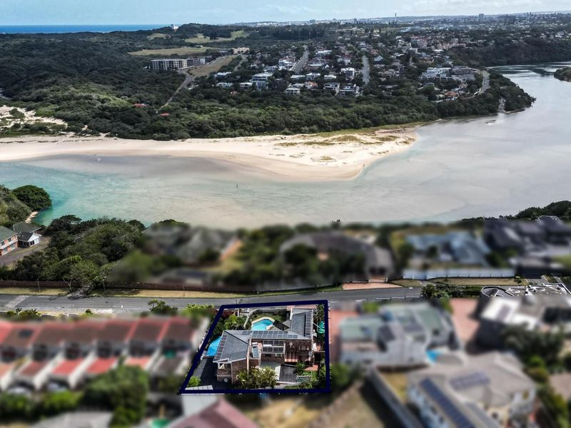 Aerial view of the property highlighting its prime location near the river mouth and coastline, featuring a private swimming pool and solar panels.