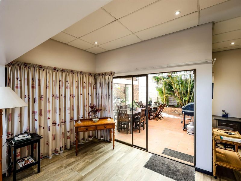 Living area featuring sliding glass doors that open onto a paved outdoor patio space.
