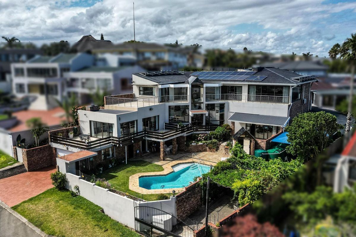 Aerial view of a multi-level residential property featuring a swimming pool, landscaped garden, multiple balconies, and rooftop solar panels.