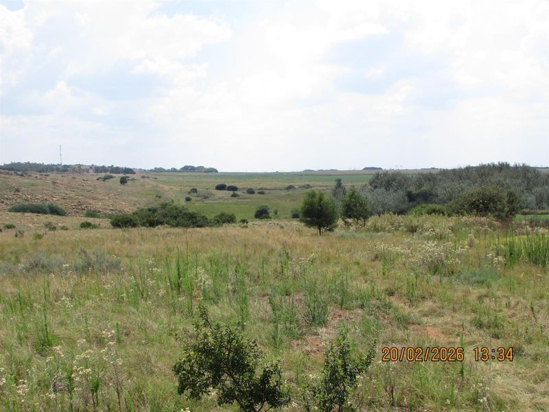 A wide-angle view of the expansive open grassland and natural landscape characteristic of the farm property.