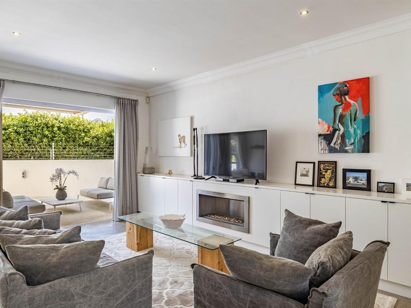 Spacious living room featuring built-in cabinetry, a modern recessed fireplace, and large sliding doors providing seamless access to the outdoor patio area.
