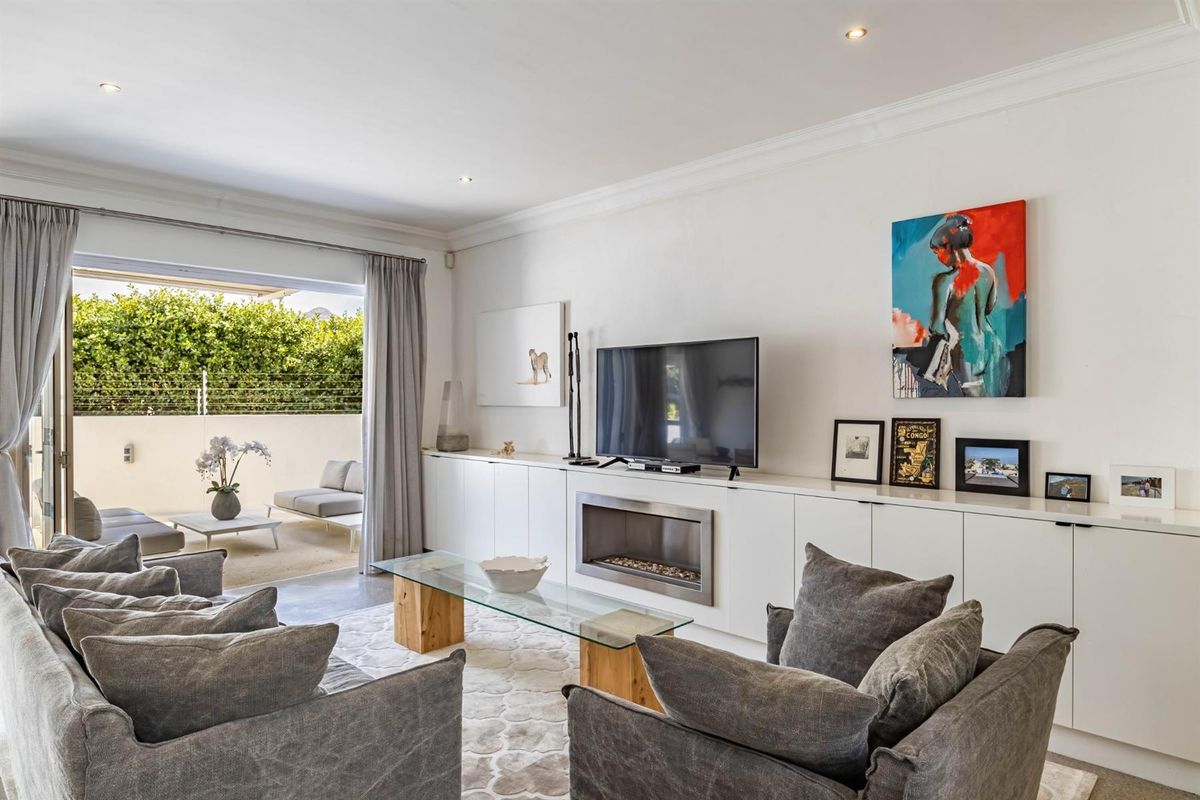 Spacious living room featuring built-in cabinetry, a modern recessed fireplace, and large sliding doors providing seamless access to the outdoor patio area.