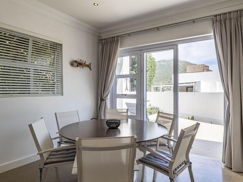 A bright dining area featuring crown molding, recessed lighting, and large sliding glass doors that provide direct access to the outdoor patio area.