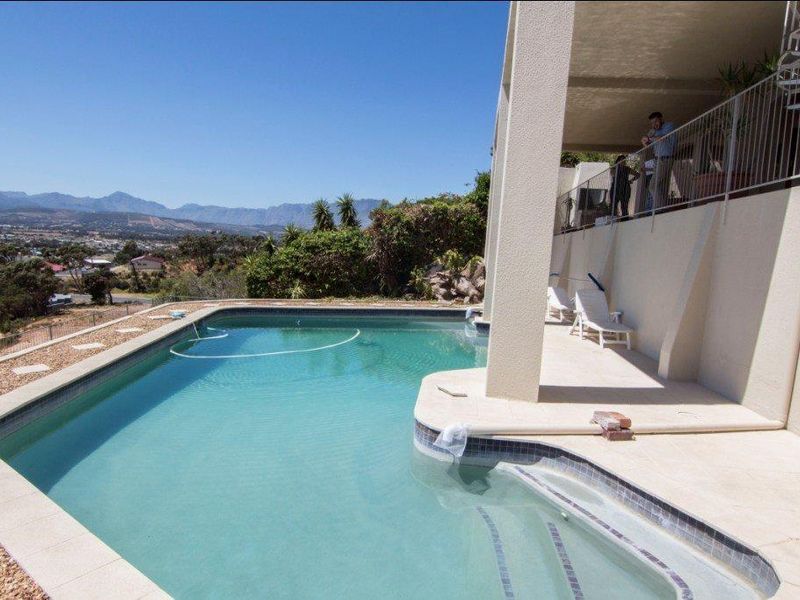 Outdoor pool area featuring a swimming pool with mountain views and an adjacent covered patio space.