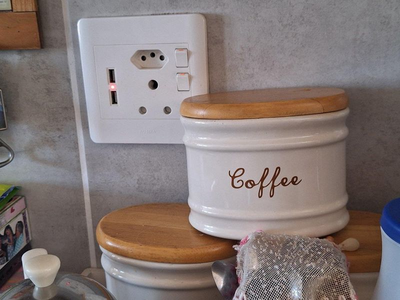 Close-up view of a kitchen wall featuring a modern electrical outlet with integrated USB charging ports and tiled splashback.