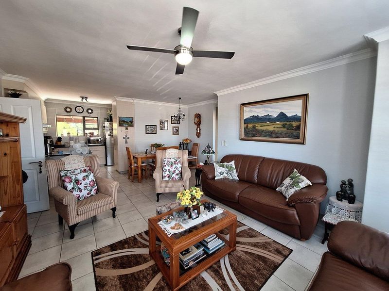 Open-plan living and dining area featuring tiled flooring, a ceiling fan, and a seamless transition to the adjacent kitchen space.