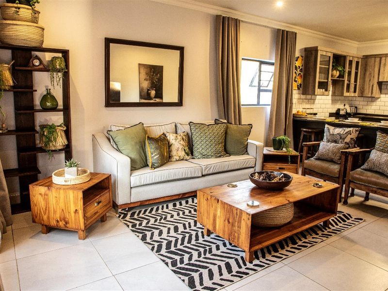 An open-plan living area featuring tiled floors, recessed lighting, and a modern kitchen with subway tile backsplash and built-in cabinetry.