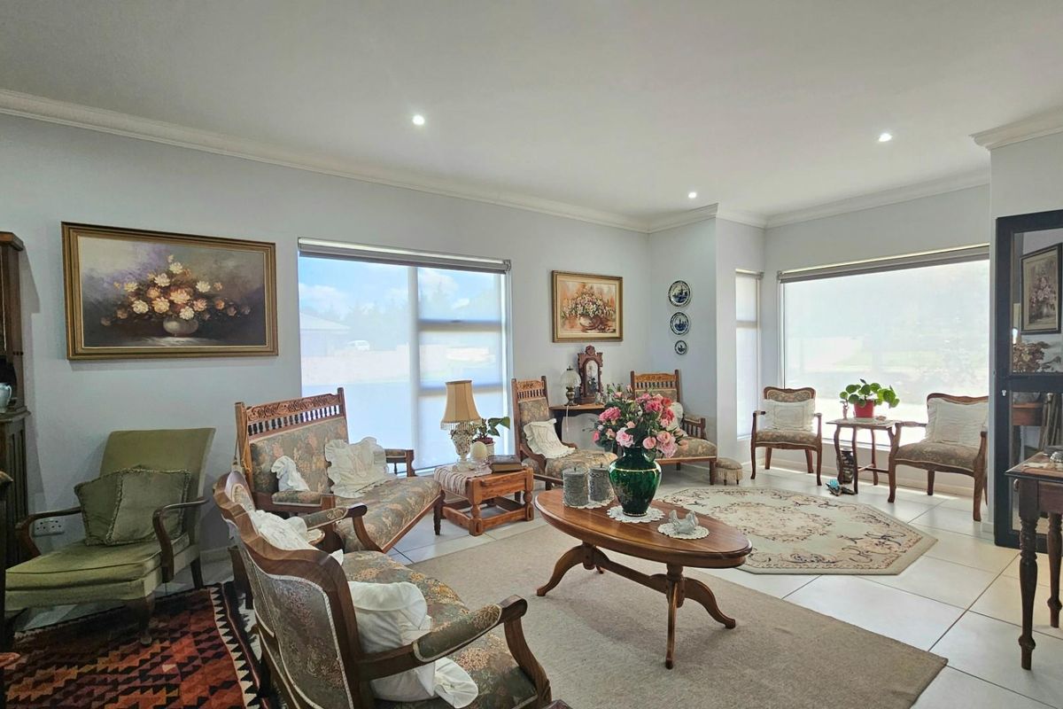 Spacious living room featuring large windows, recessed downlighting, and neutral tiled flooring, offering a bright and open atmosphere.