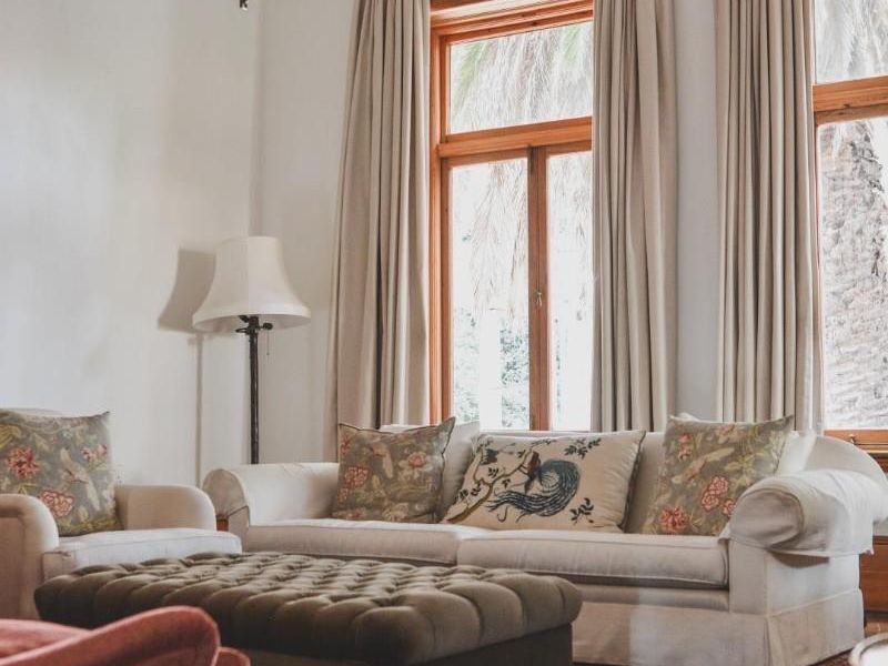 Elegant living room featuring a classic coffered ceiling with ornate detailing, large timber-framed windows, and polished hardwood flooring.